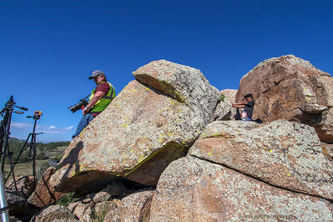 Daecian behind a boulder as he and Derek Buffie Brown wait for a train.