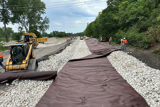 BNSF teams place rock base layer and overlaying geotextile fabric to help with stabilization.